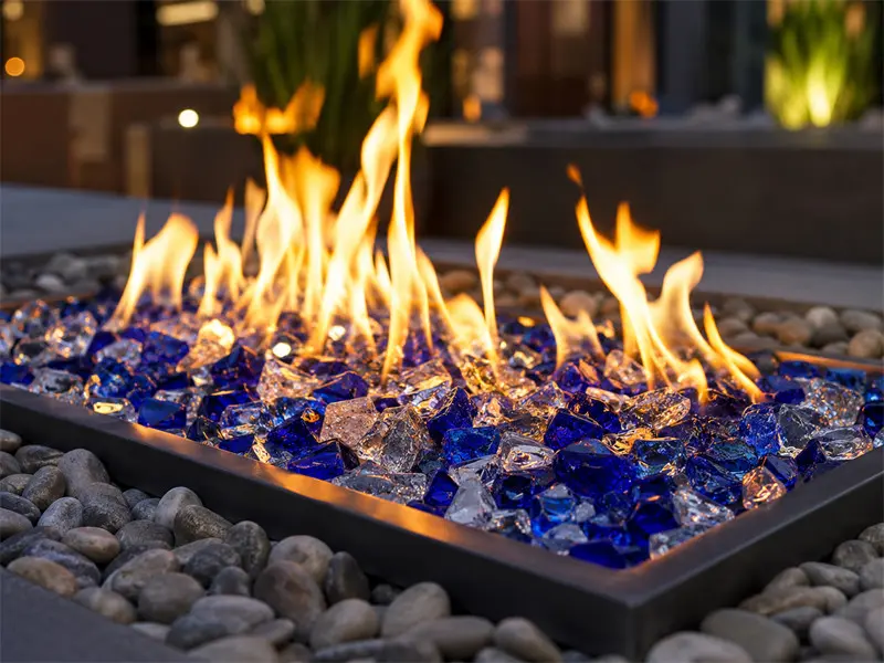 Modern outdoor fire pit with blue decorative fire glass for luxury patio and garden landscaping