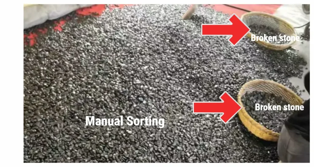 Skilled worker manually removing broken or flawed black pebbles to ensure only premium quality products are packed for export.