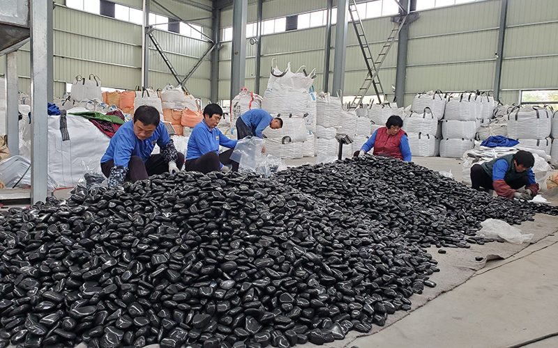 Black polished pebbles sorting and production at decorative stone factory